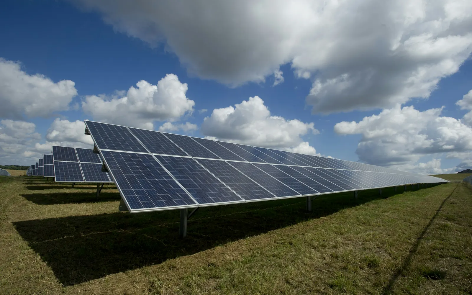 Photovoltaik-Freiflächenanlage mit Modulreihen unter bewölktem Himmel